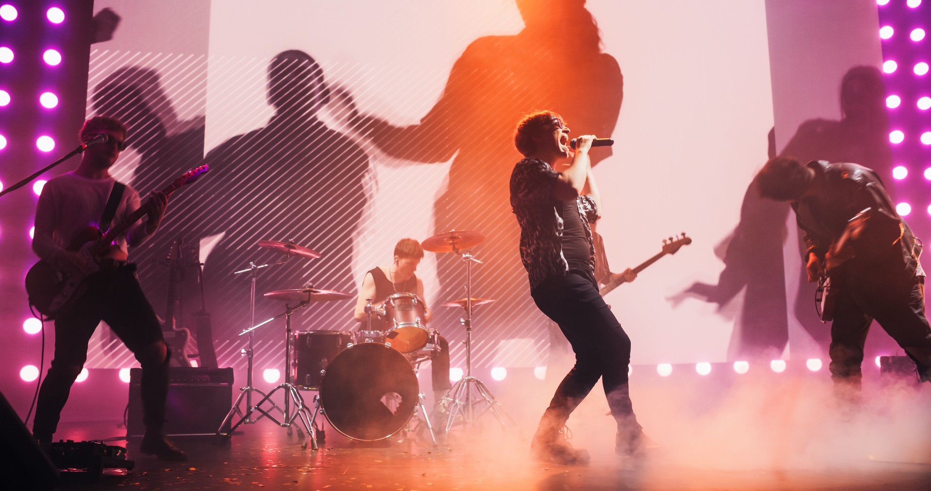 Talented Rock Band Performing a Live Set on an Indoors Stage with Visual Art Display. Young Musicians Playing a Concert at a Festival, Singing Hard Rock Songs at an Indie Event. Zoom On a Lead Singer